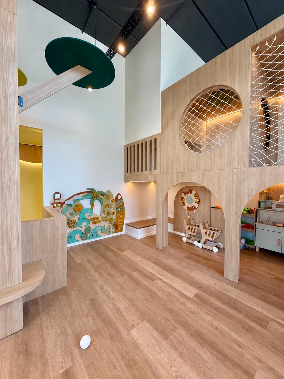 Plaza de juegos de madera con redes y panel sensorial